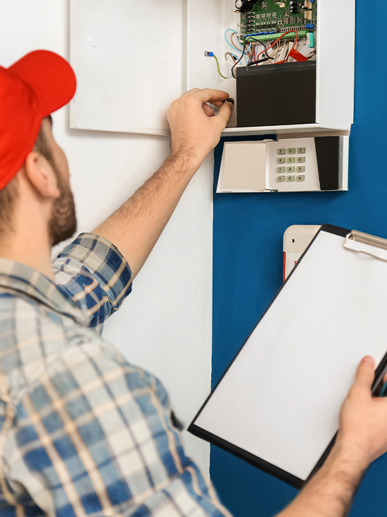 technician-installing-alarm-panel-in-home